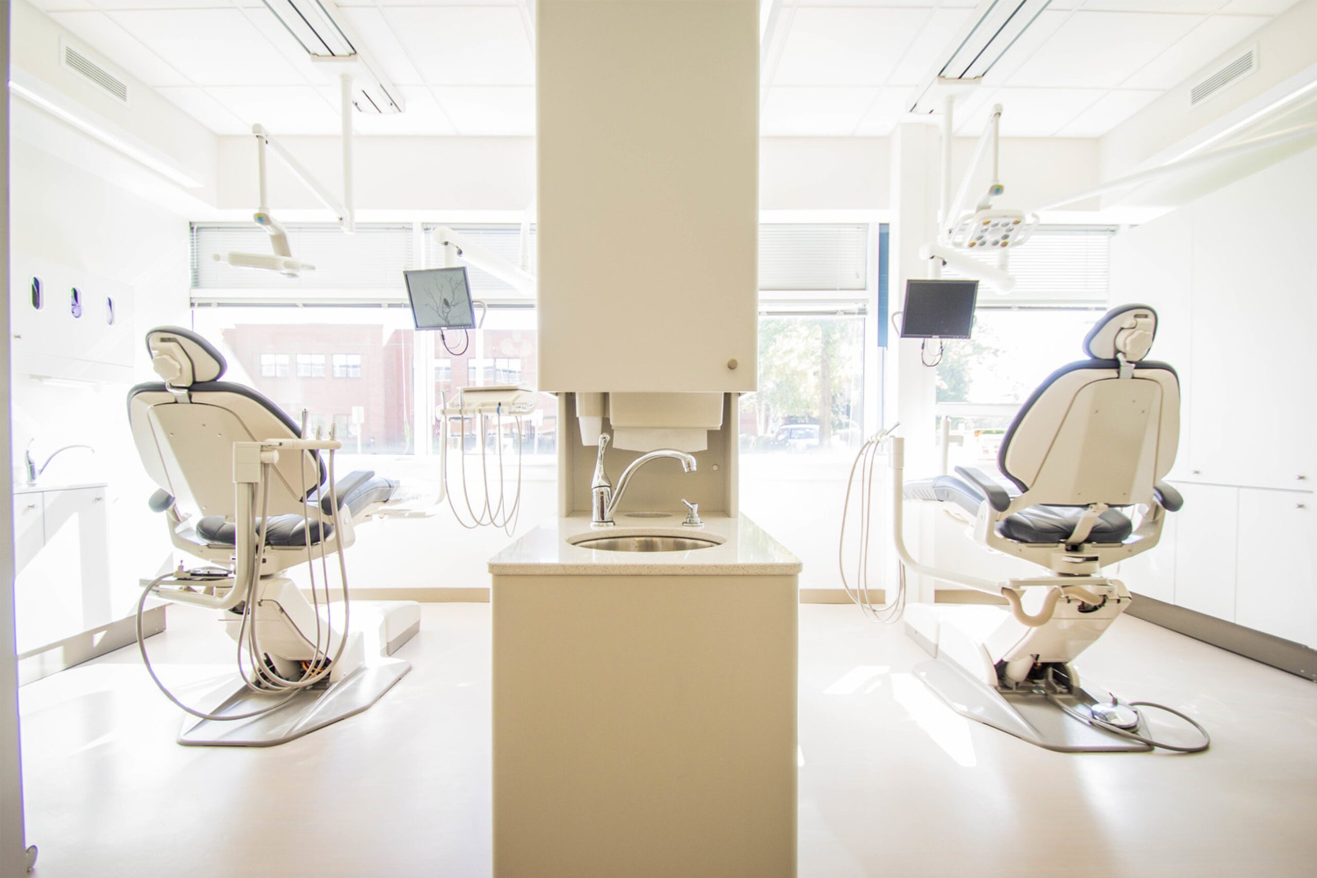 duas cadeiras de dentista em um consultório branco